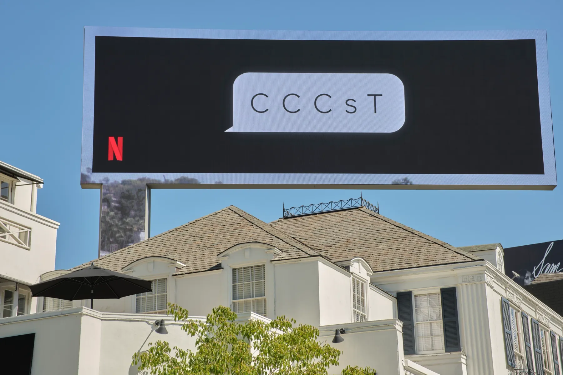 Photo of a billboard. i9t has the netflix logo in the bottom left corner, and a speech bubble that reads "C C C s T"