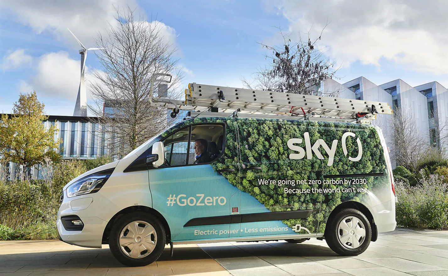 Photo of a Sky van, with trees on the side