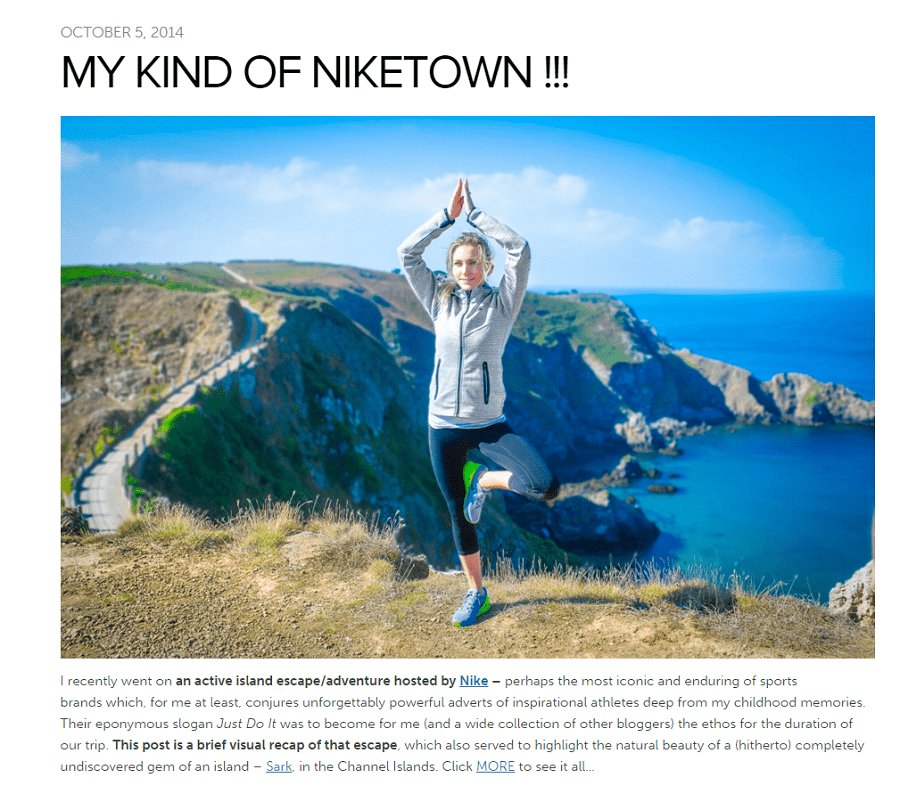 female standing in yoga pose 'the crane' in jogging equipment on a cliff with sea and cliffs in background