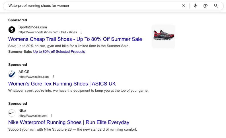 Google Ads Search Campaign showing sponsored ads by SportsShoes, ASICS, and Nike for "Waterproof running shoes for women"