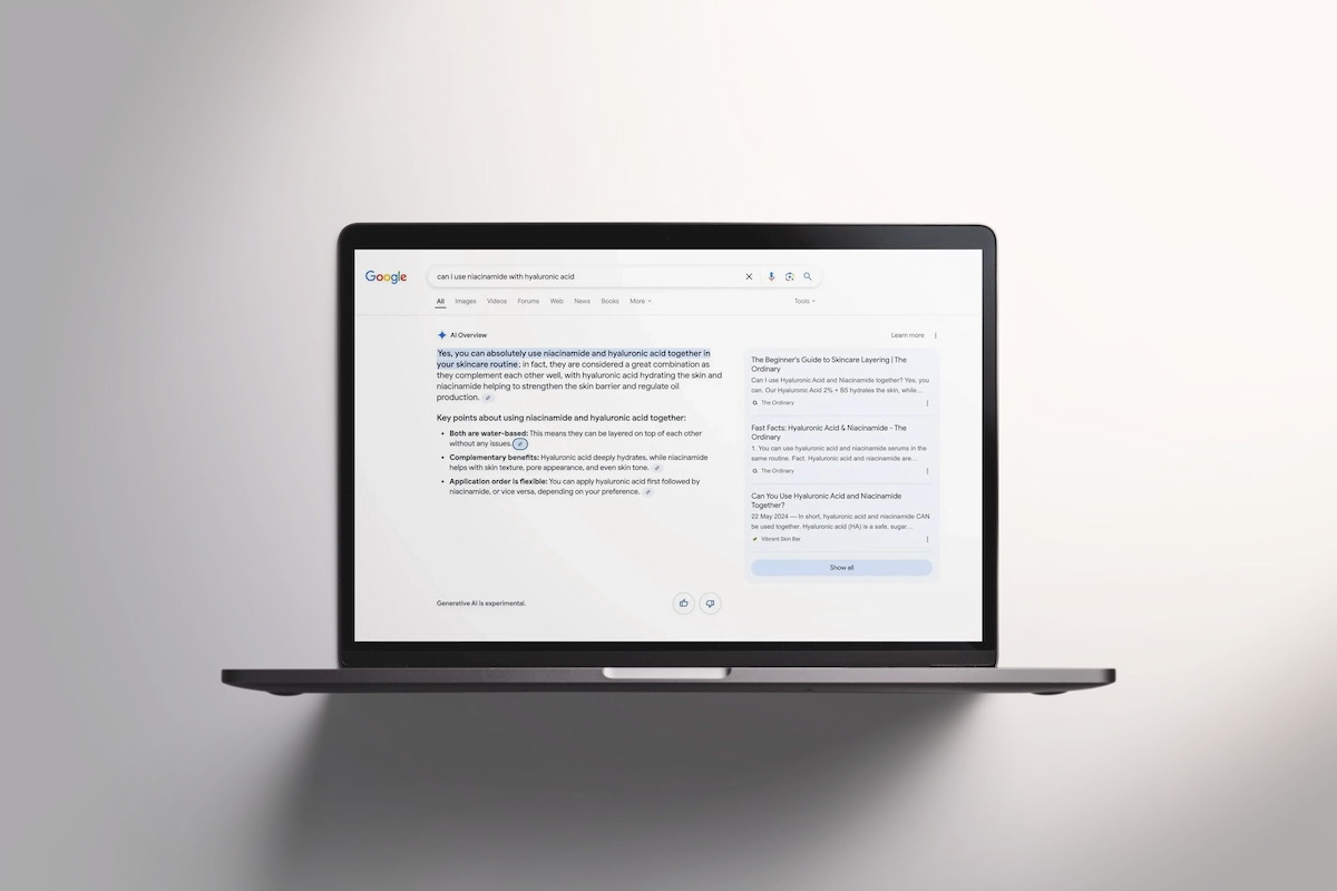 Laptop displaying a Google search results page with an AI Overview answering "can I use niacinamide with hyaluronic acid," citing The Ordinary as a source