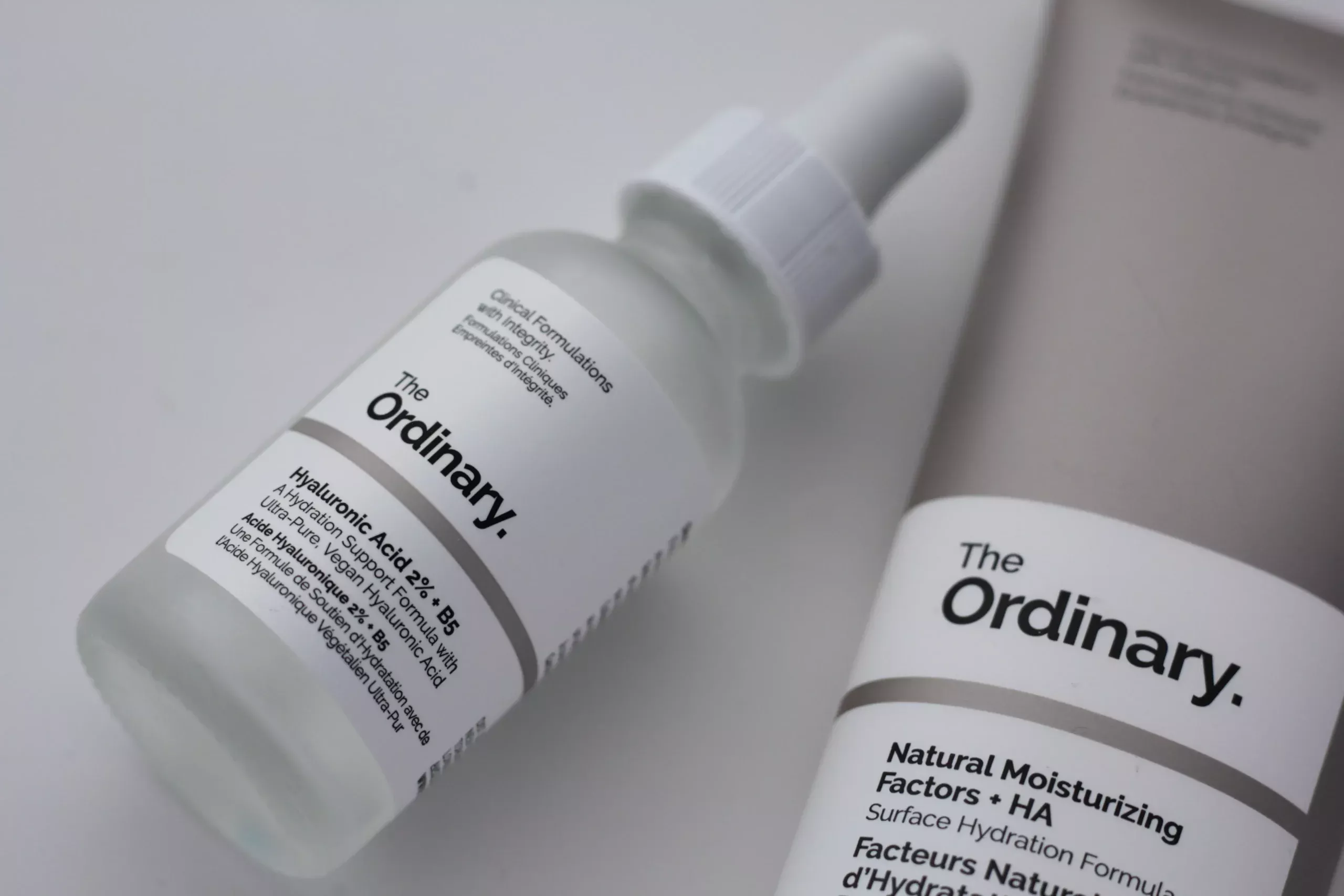 Two The Ordinary skincare products lying on a flat surface