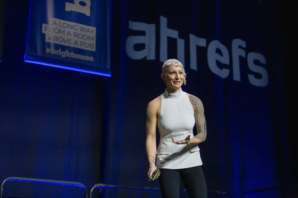 Lily Ray, SEO speaker from Amsive, on stage at BrightonSEO delivering a talk