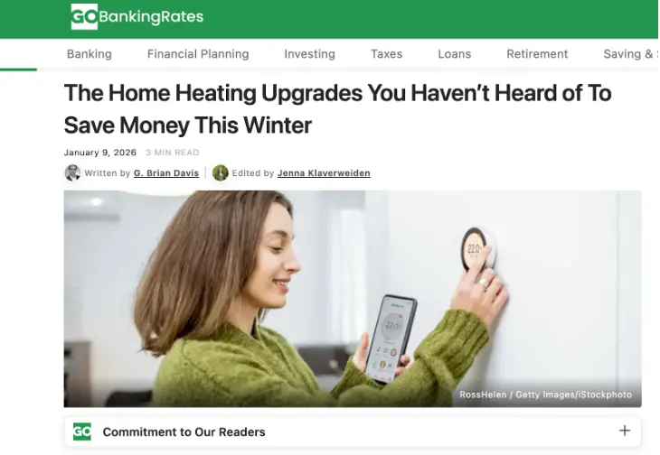Screenshot of a GOBankingRates article titled "The Home Heating Upgrades You Haven't Heard of To Save Money This Winter," with author and editor bylines and a photo of a woman adjusting a smart thermostat using her phone.
