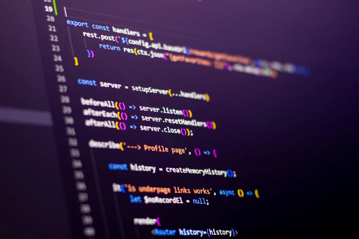 Close-up of a computer screen displaying colorful JavaScript testing code with syntax highlighting on a dark background.
